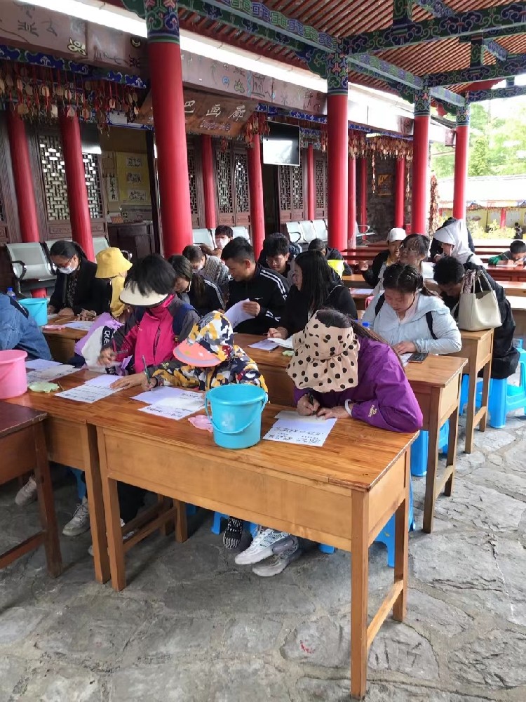 2023年4月22日一群游客在丽江玉水寨风景区体验了东巴文字的书写