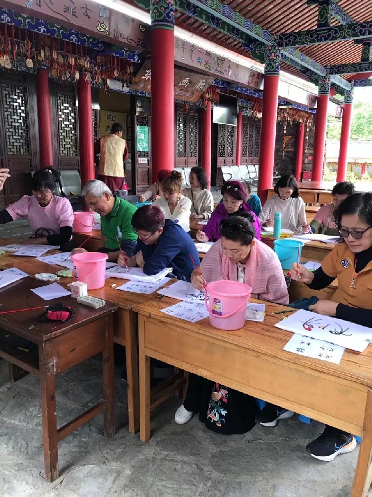 马来西亚游客在玉水寨体验东巴文化T恤绘制