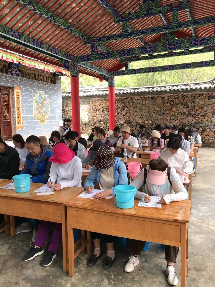 游客在东巴文化传承院学习体验东巴文化