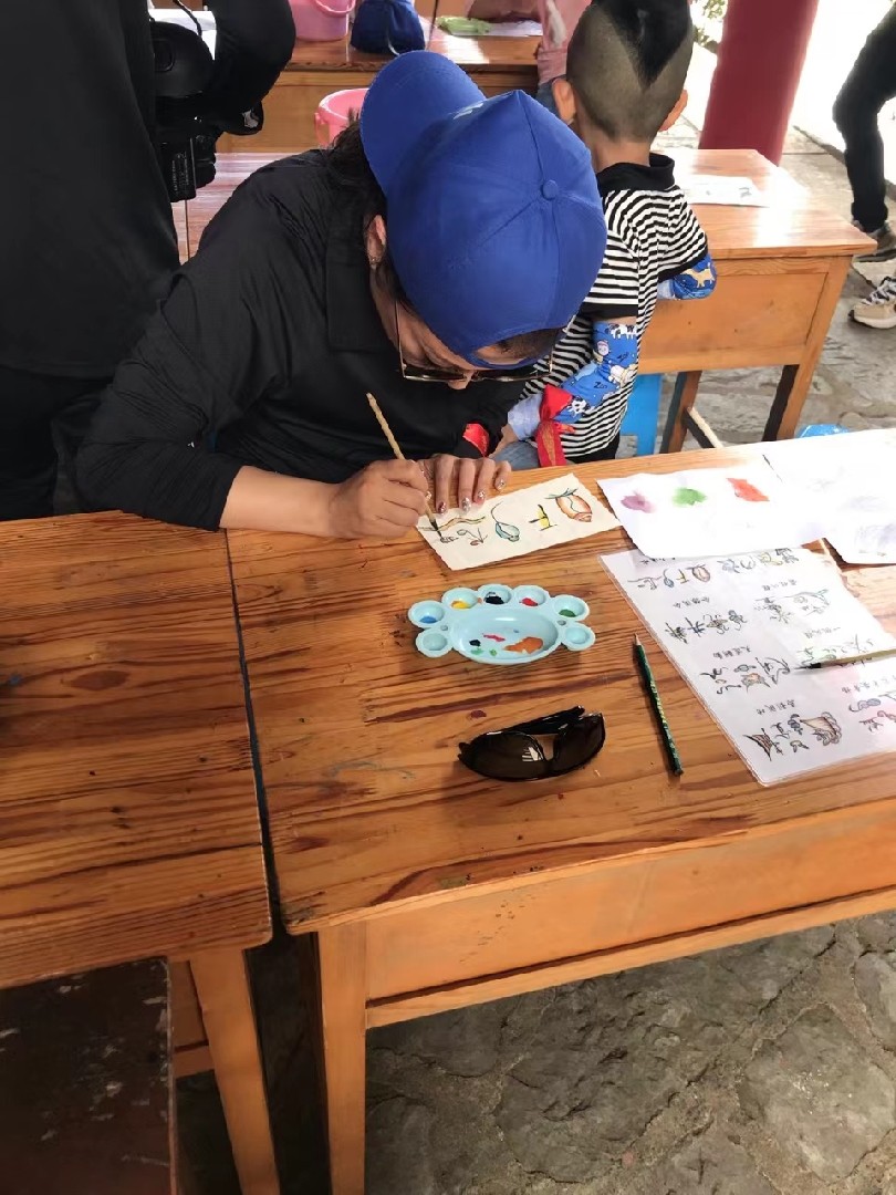 游客在玉水寨景区体验制作东巴纸镜框